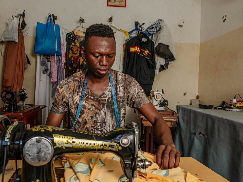 Tailor at work behind a sewing machine in his studio